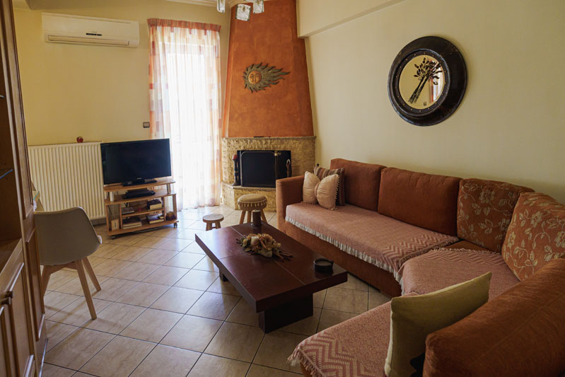 Σαλόνι με τζάκι – μεζονέτα στη ΝίκαιαΓωνιακός καναπές & τζάκι – real estate φωτογράφιση ,Μεζονέτα Νίκαια Αττικής - Cinematic Luxe Studio